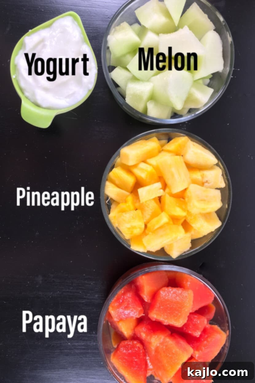 A vibrant flat lay showcasing the fresh ingredients for homemade papaya popsicles: ripe papaya, juicy pineapple, cool honeydew melon, and creamy Greek yogurt.