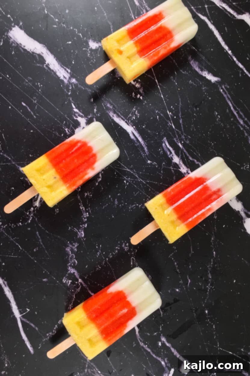 Three vibrant layers of melon, papaya, and pineapple form delicious no-sugar-added popsicles in molds.