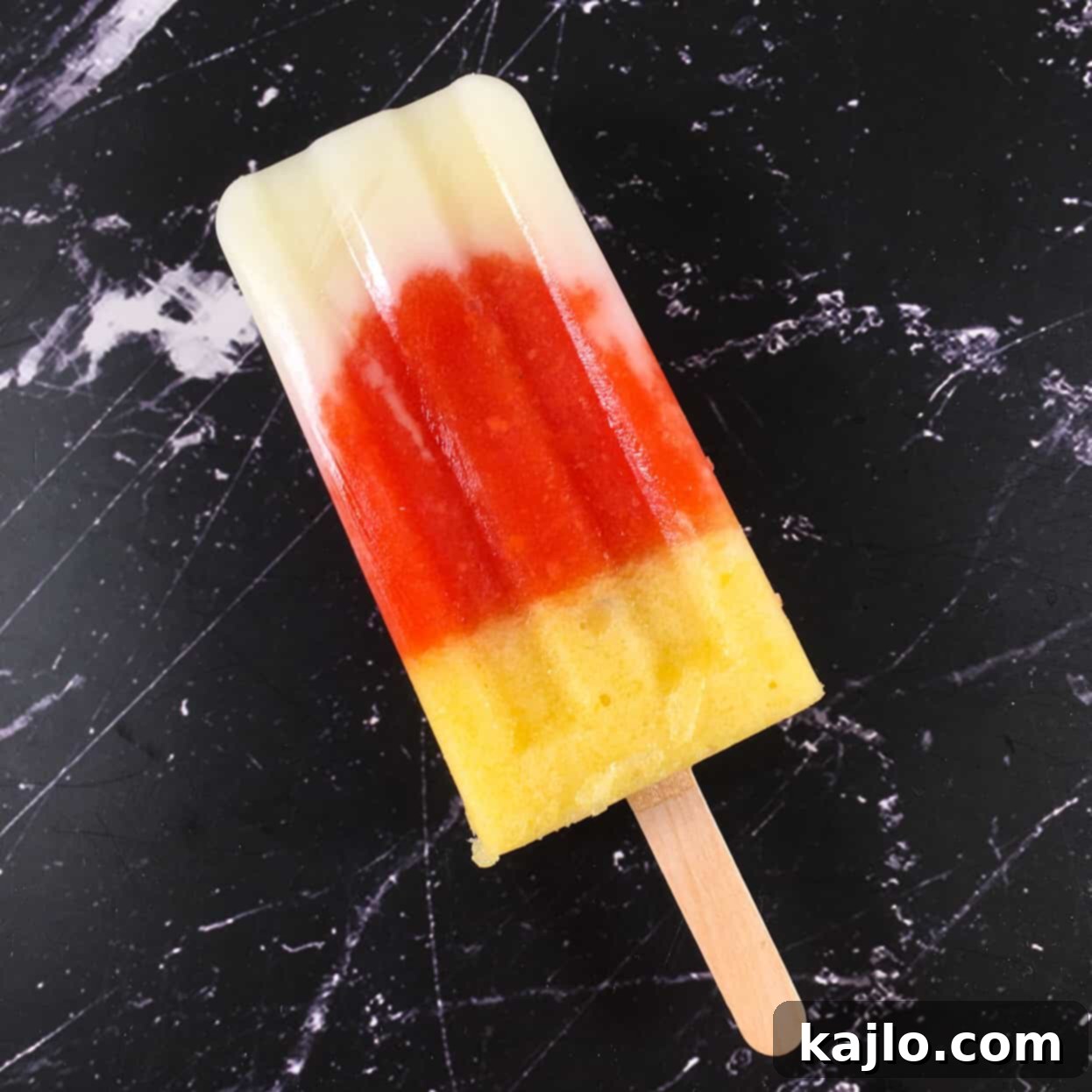 A refreshing trio of melon, papaya, and pineapple popsicles displayed, showcasing the vibrant layered colors of the recipe.