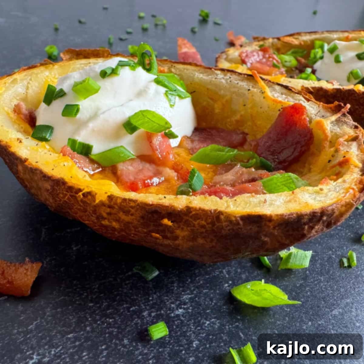 A single air fryer potato skin garnished with sour cream and chives