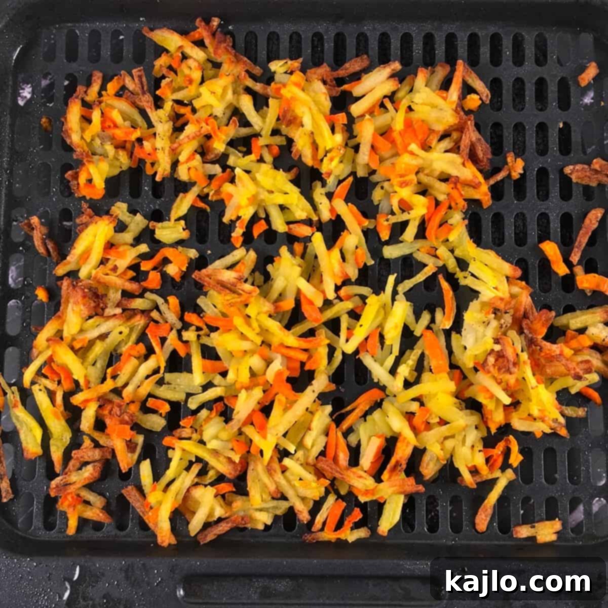 Golden-brown, crispy air fried hash browns in an air fryer basket.