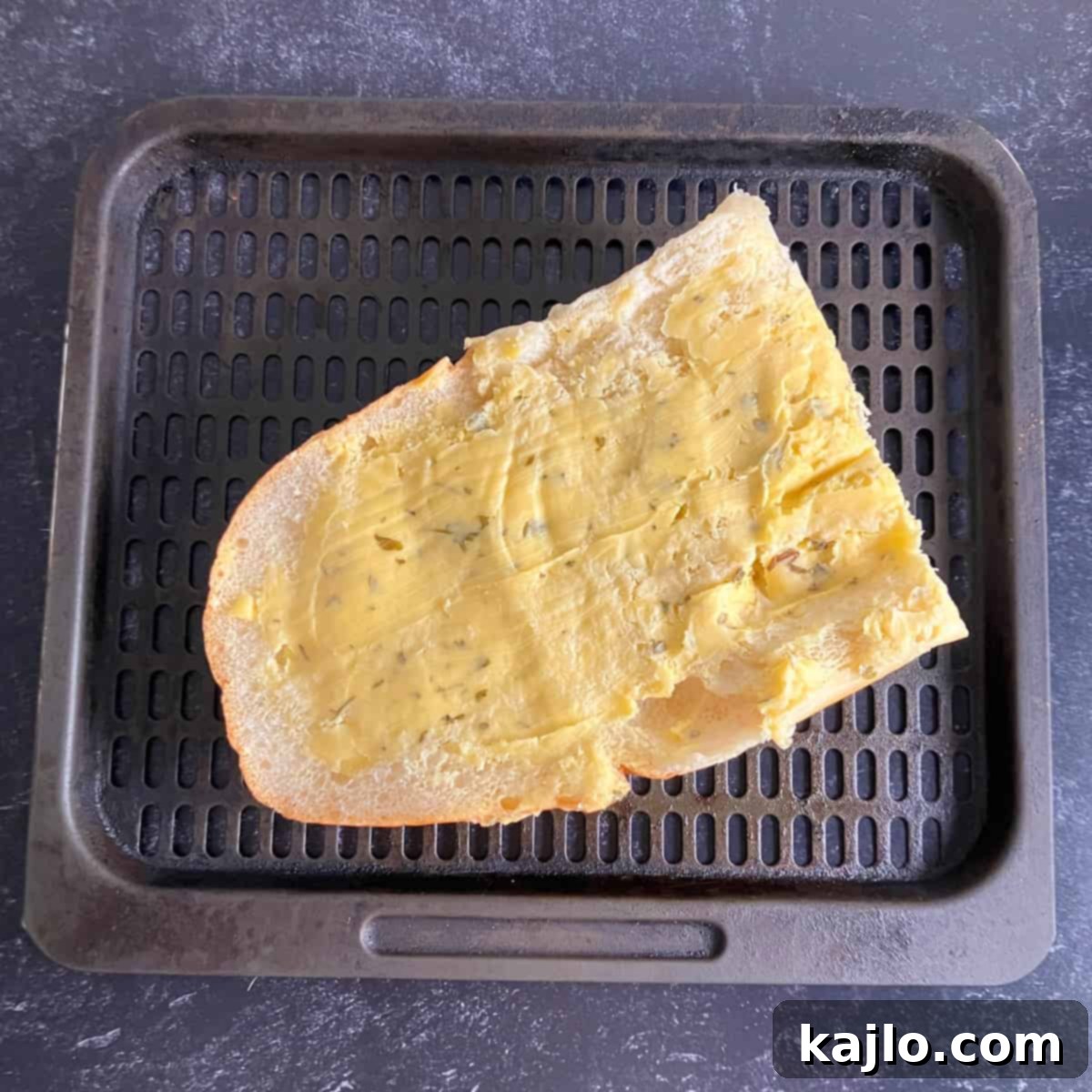 Air Fryer Foil Pack Garlic Bread 4 Garlic bread halves with butter spread evenly, ready to be cut and air fried.