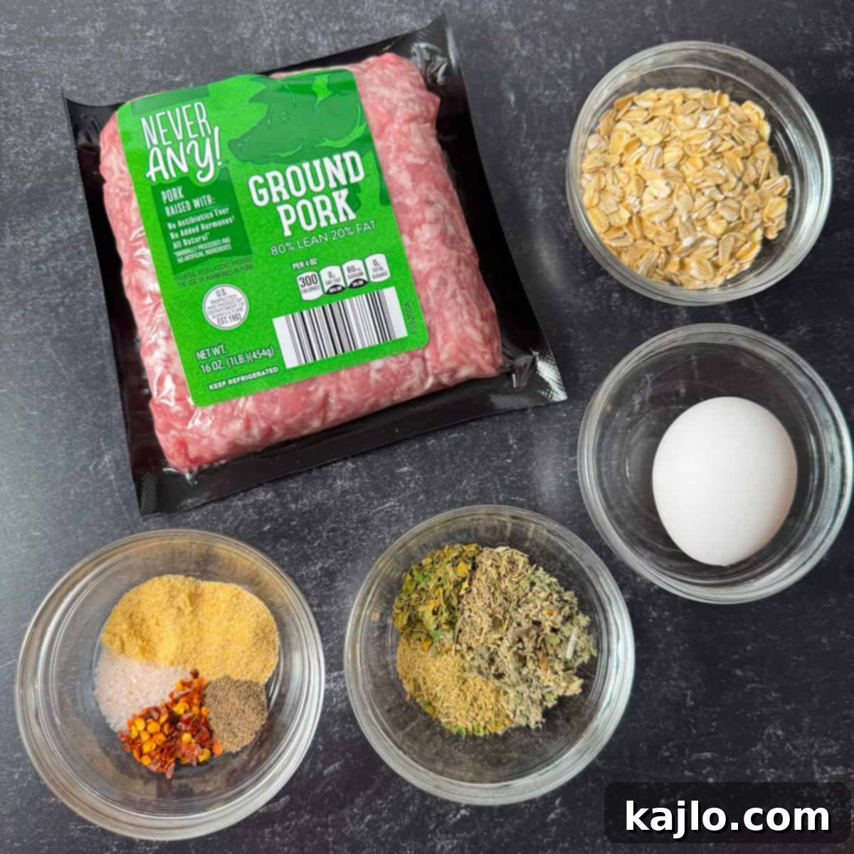 Ingredients laid out for air fryer sausage patties, including ground pork, spices, oats, and an egg.
