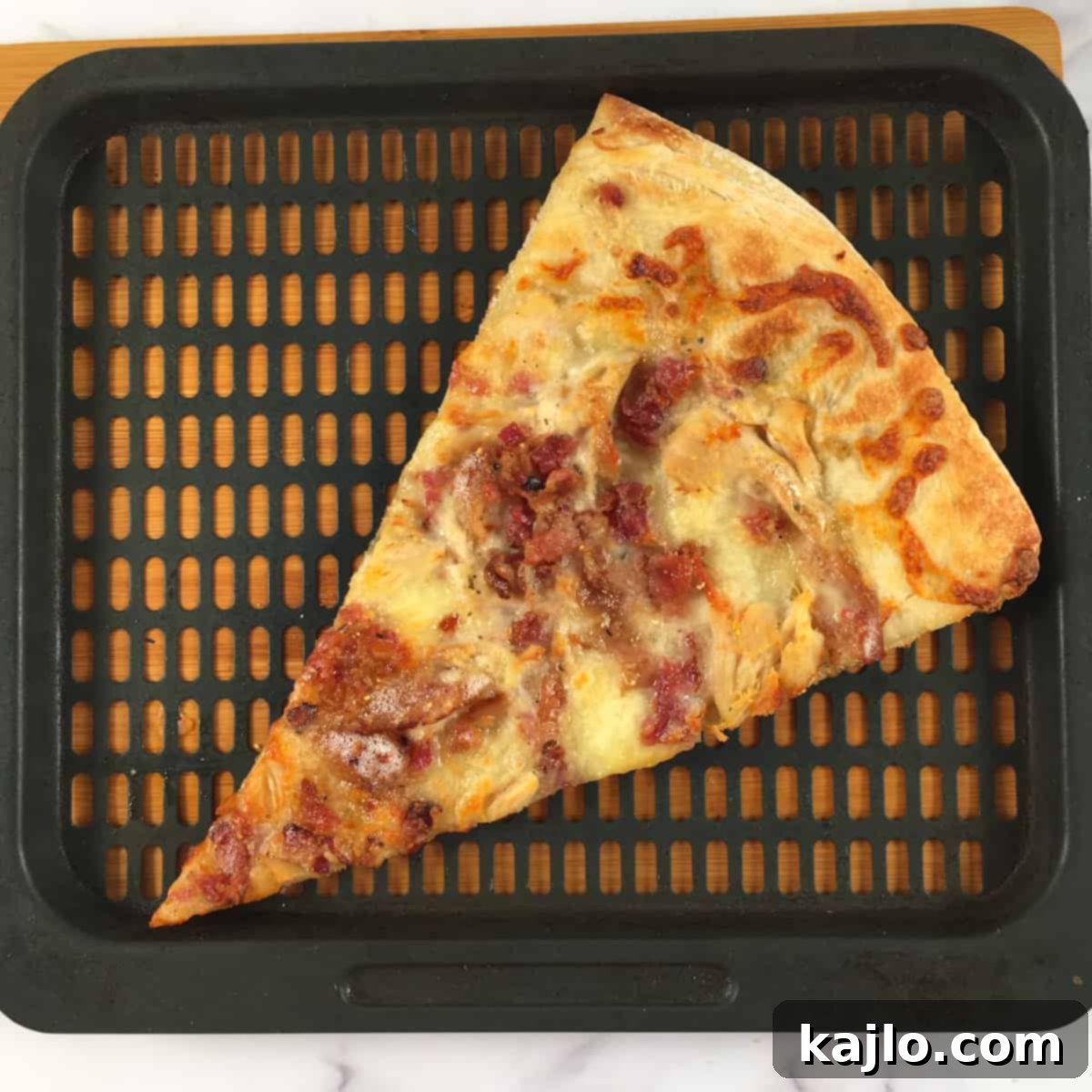 Pizza slice being reheated in an air fryer basket