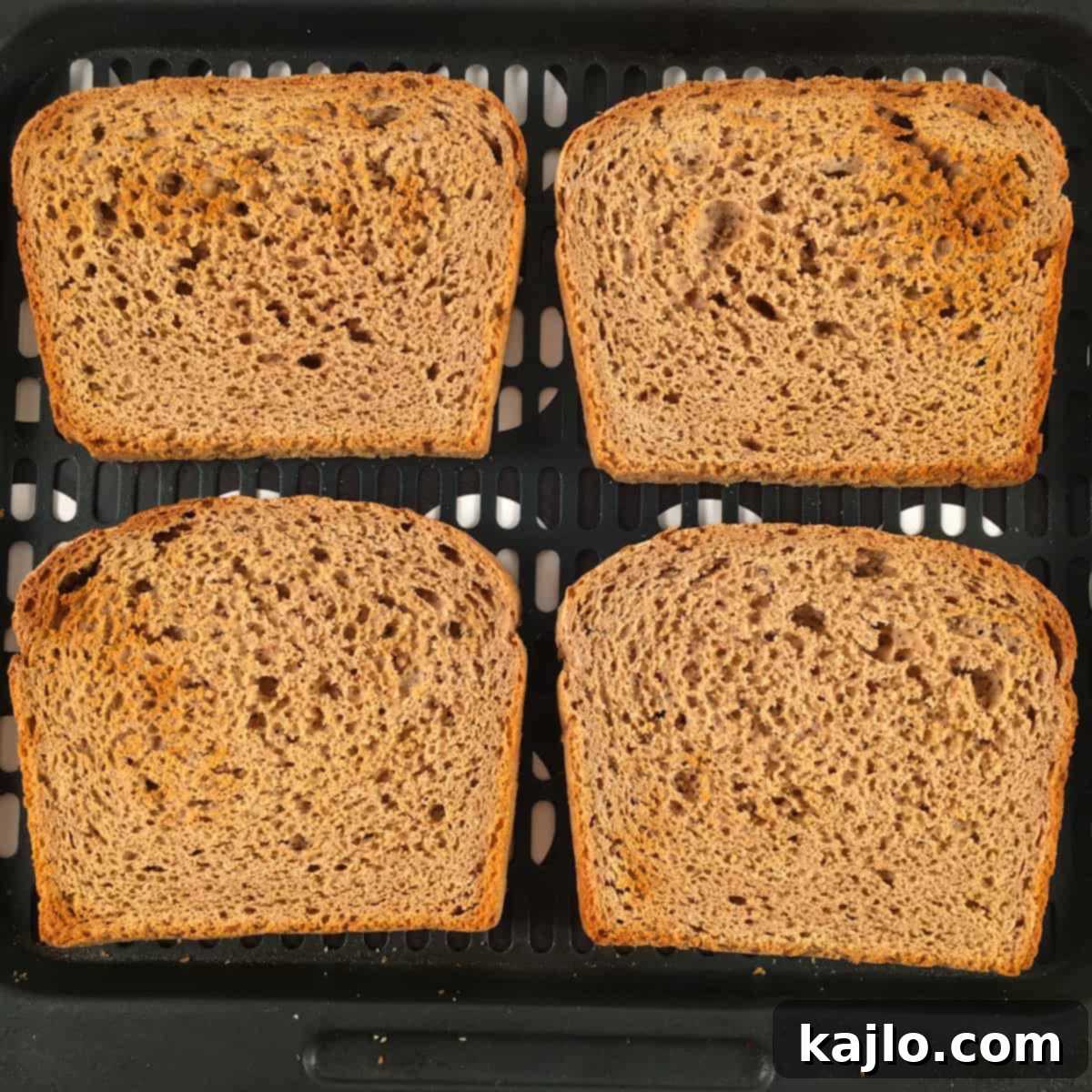 Several slices of freshly toasted bread in an air fryer basket.