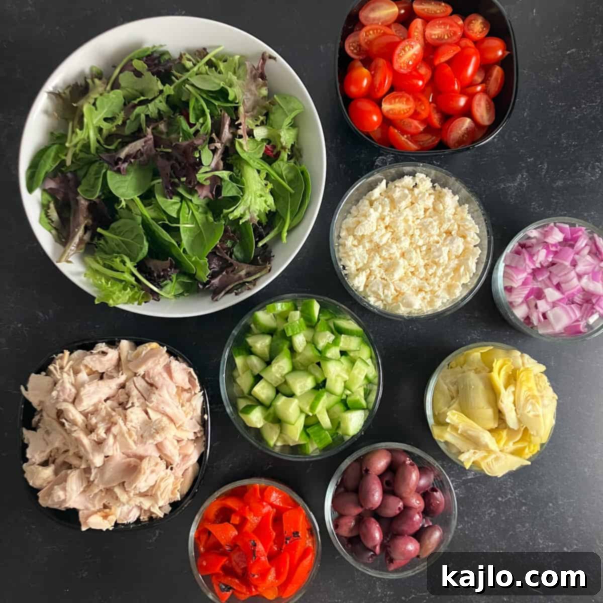 Collection of fresh ingredients for making a keto Greek salad with chicken.