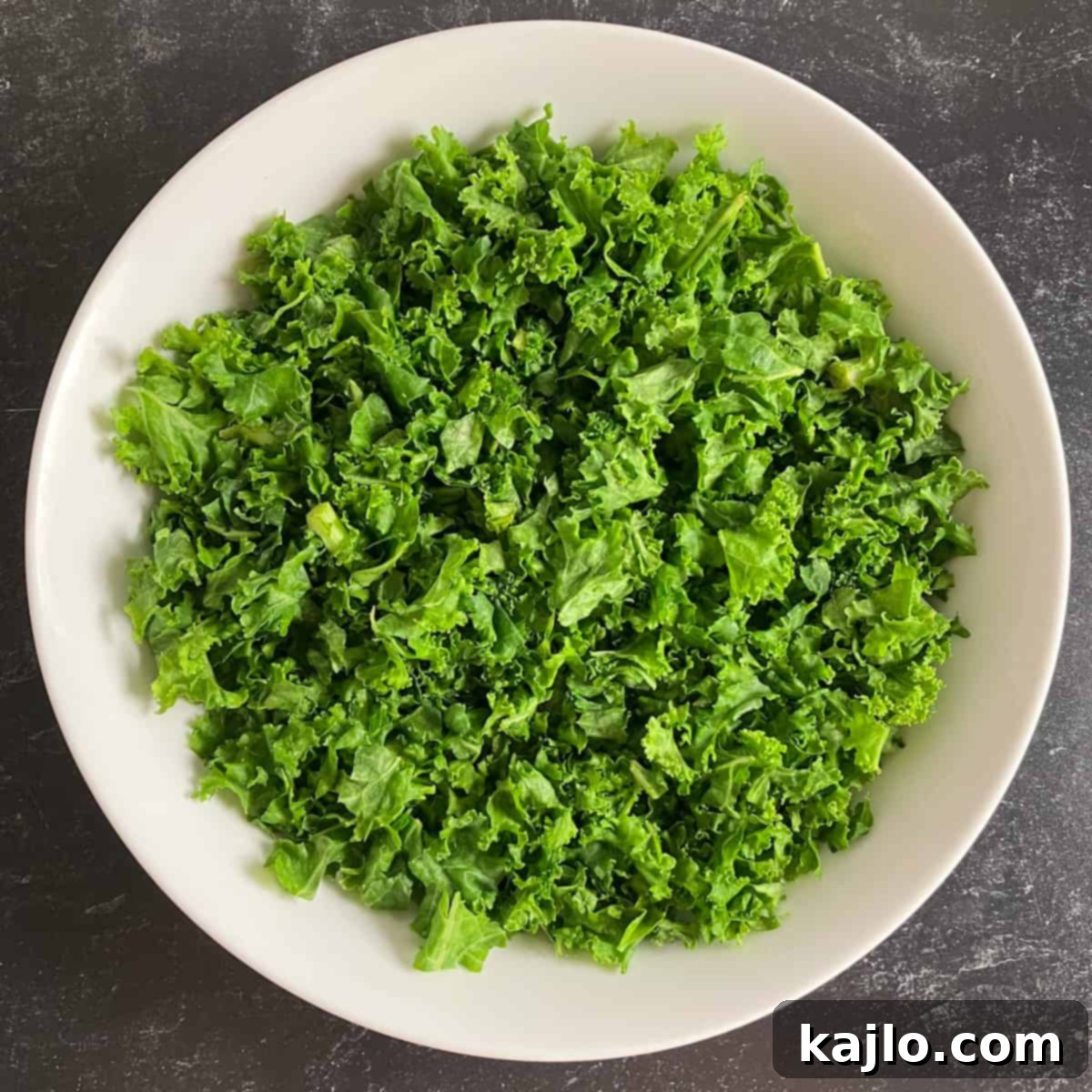 Light Plant-Powered Bowls for Vibrant Health 8 Fresh massaged kale leaves, forming the low calorie base of a nourish bowl