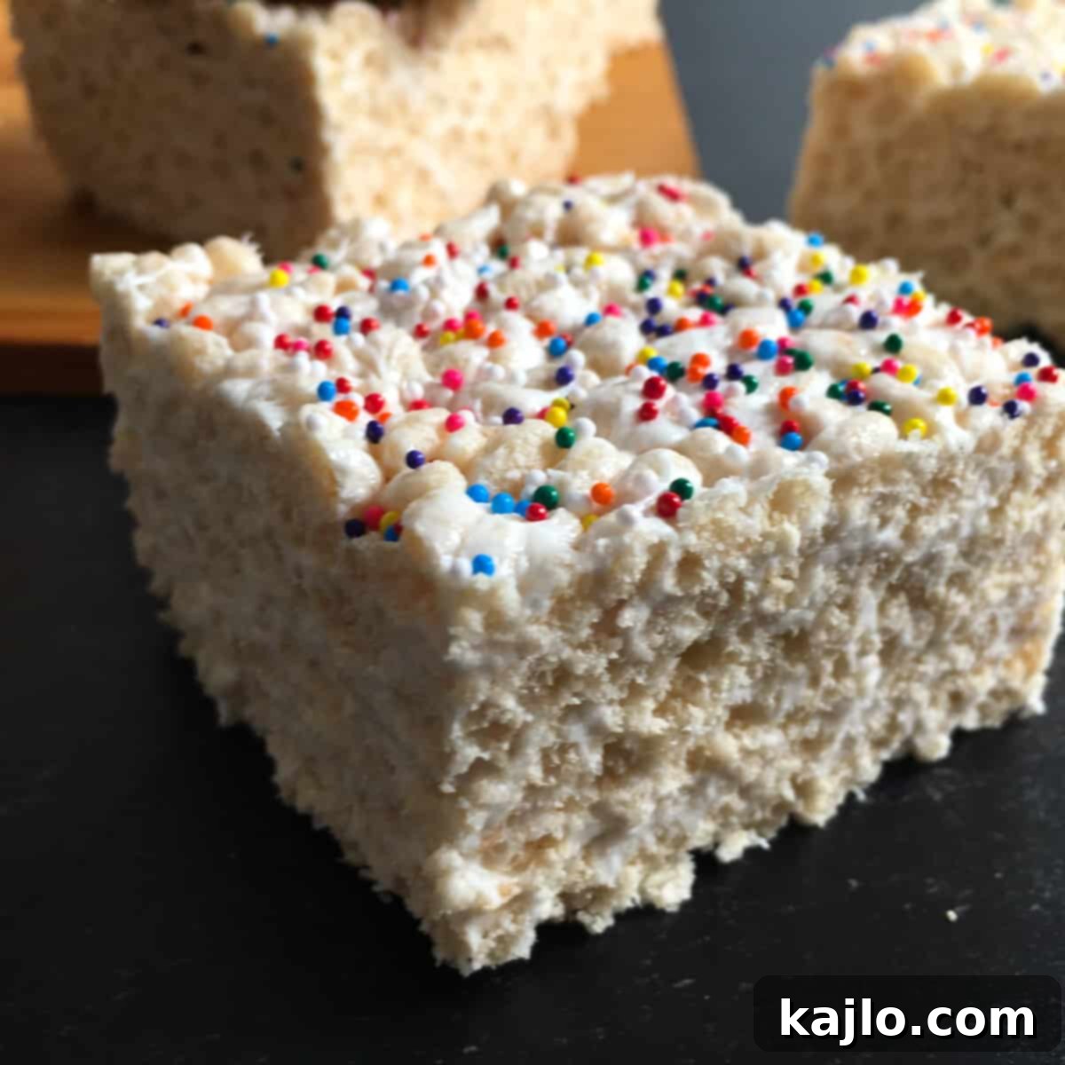 No-Bake Vegan Crispy Treats 2 Irresistible vegan rice crispy treat squares on a white background, garnished with colorful sprinkles.