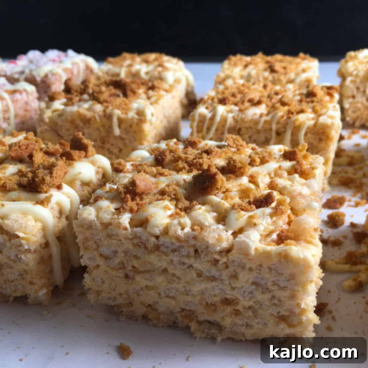 No-Bake Vegan Crispy Treats 13 Close-up of pumpkin spice rice crispy treats with a drizzle of white chocolate and crumbled ginger snaps.