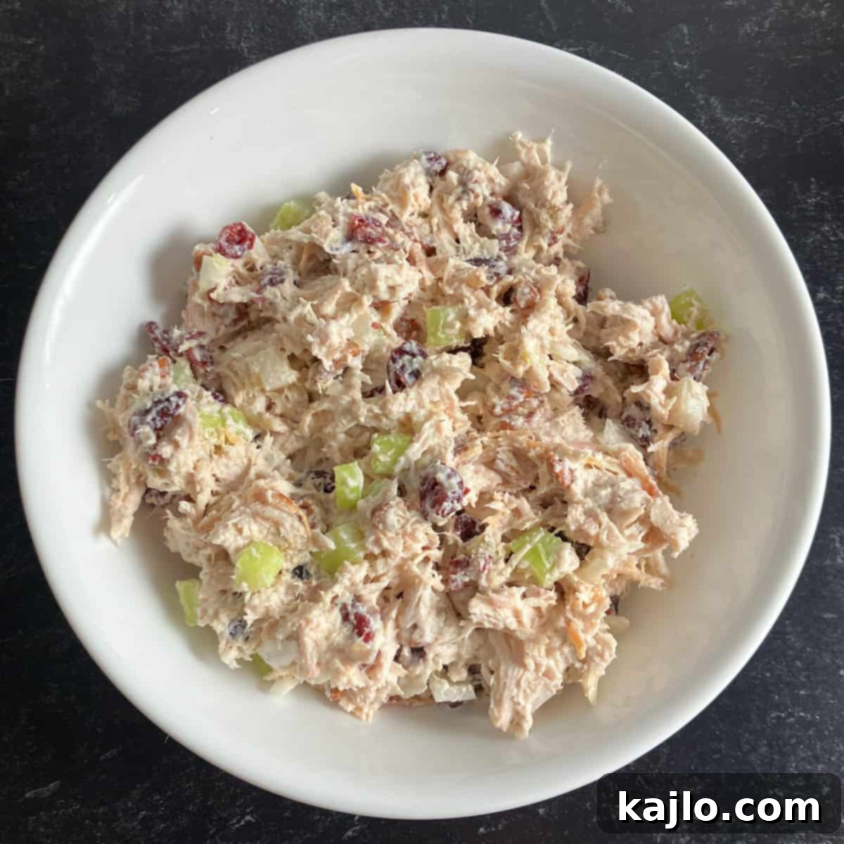 mixing ingredients for turkey salad without mayo in a bowl