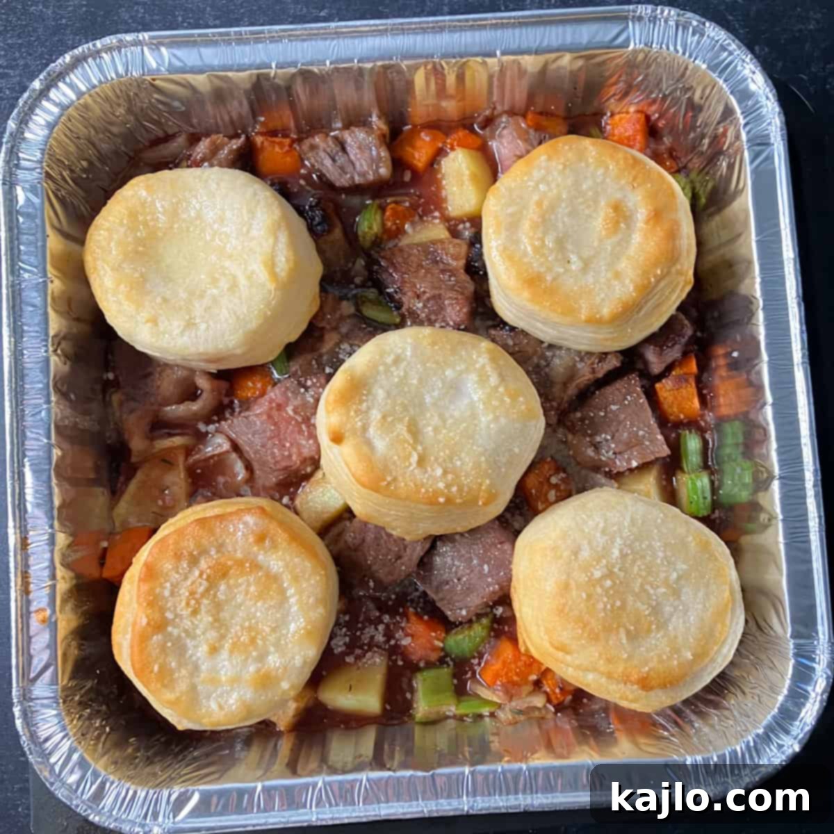 Assembled beef stew mixture with biscuits on top, ready for final air frying.