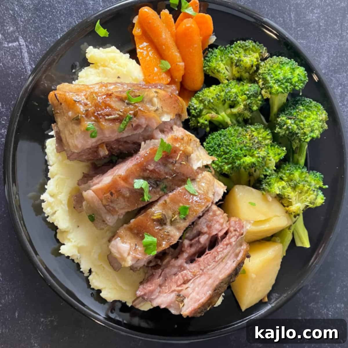 A complete meal featuring lamb breast with mashed potatoes and green beans