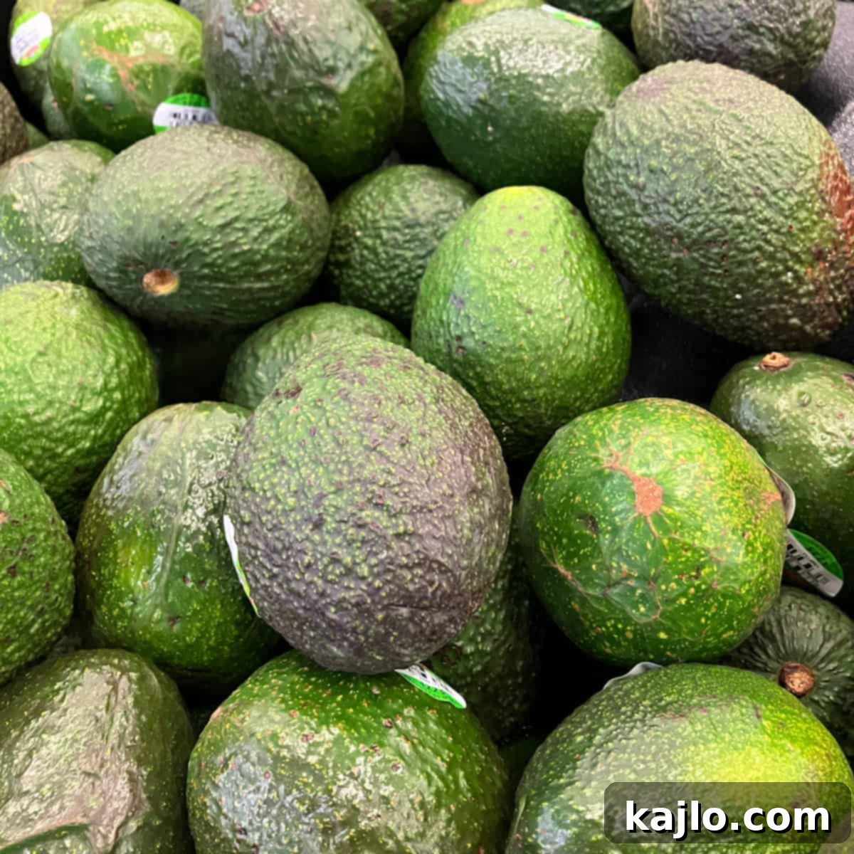 Spotty Avocado: Is It Still Good to Eat 2 Fresh, whole avocados resting on a rustic wooden surface, symbolizing the start of a culinary journey and the potential for discovering brown spots.