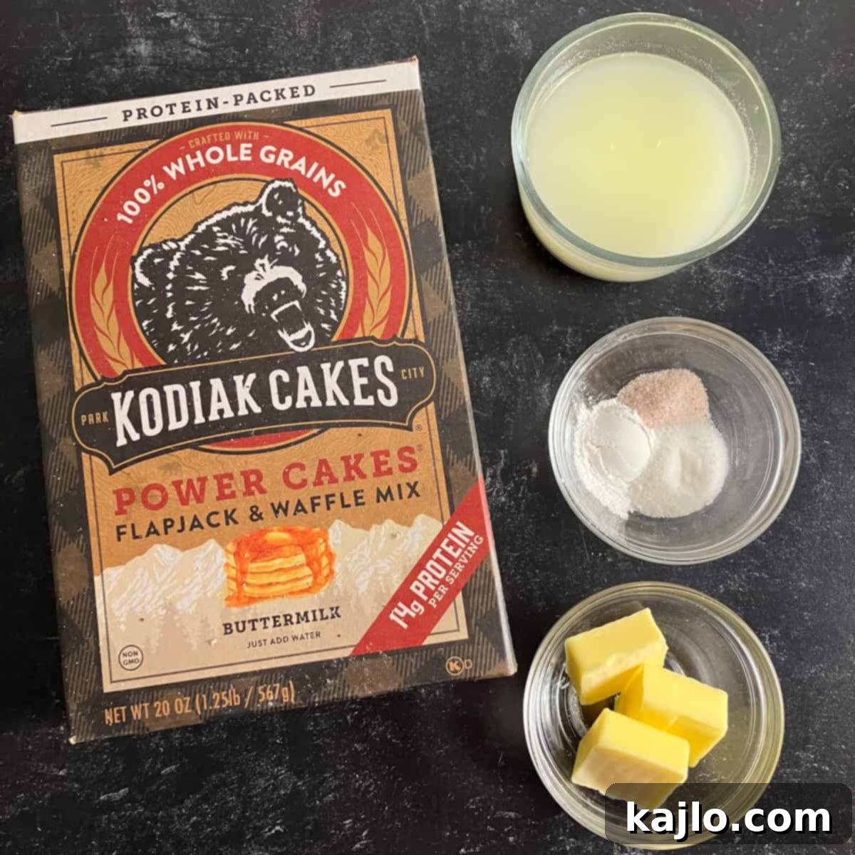 A selection of high protein biscuit ingredients including Kodiak Cakes mix, butter, and buttermilk.