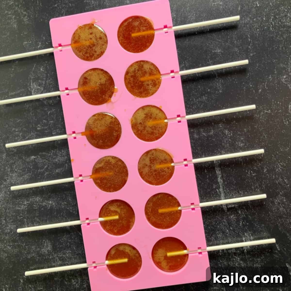 Soothing Honey Lollipops for Coughs and Tea 7 Silicone mold being filled with honey mixture to create lollipops.