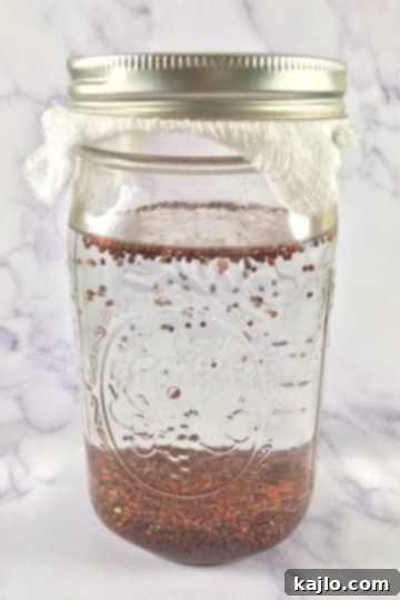 Broccoli sprout seeds soaking in lukewarm water inside a glass jar
