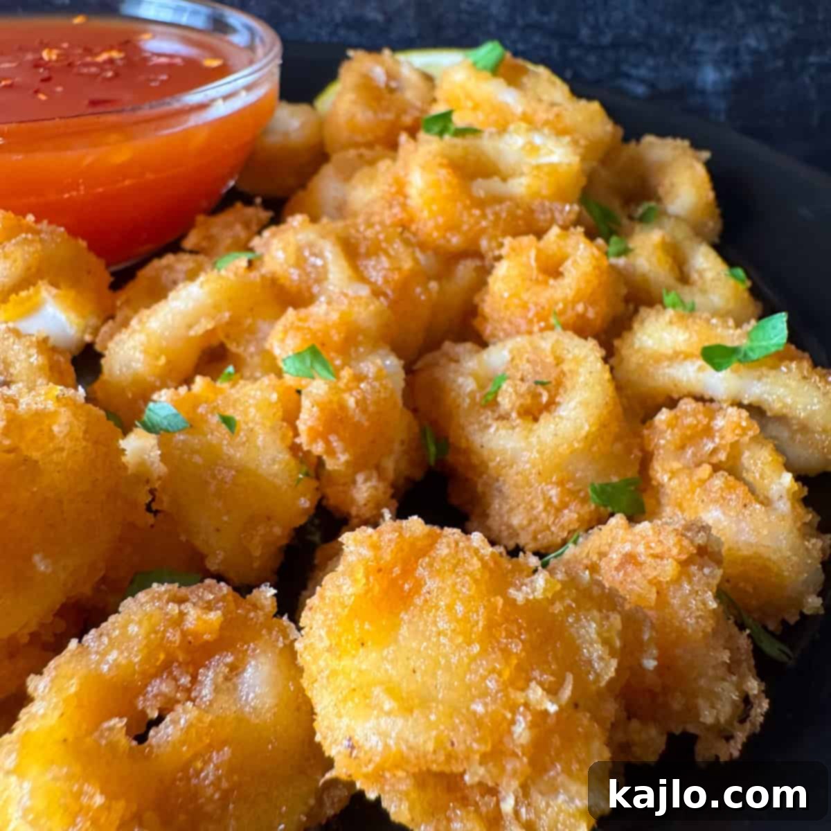 Pork Rind Crusted Air Fryer Calamari 2 Crispy air fryer calamari rings served with lemon wedges and dipping sauce