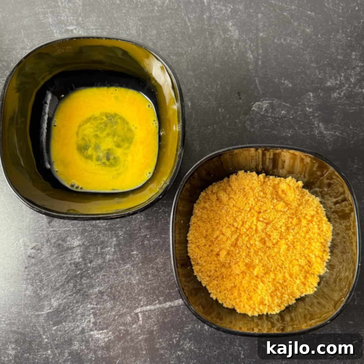 Pork Rind Crusted Air Fryer Calamari 5 Breading station set up with whisked egg and seasoned pork panko for calamari