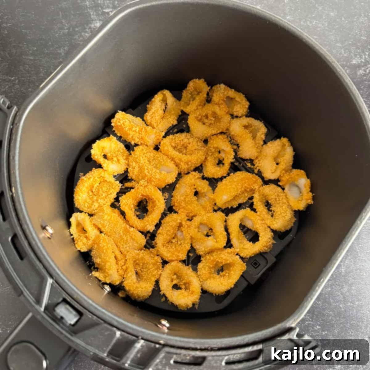 Pork Rind Crusted Air Fryer Calamari 6 Coated calamari rings arranged in a single layer in the air fryer basket