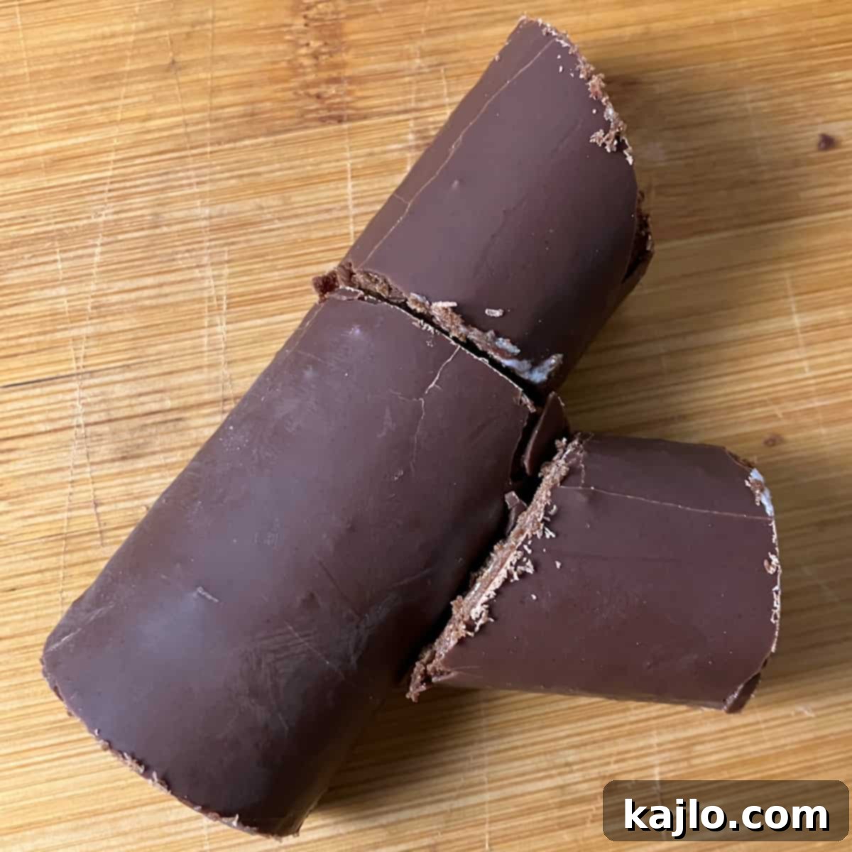 Assembling the no-bake Yule log using Swiss rolls and chocolate frosting.