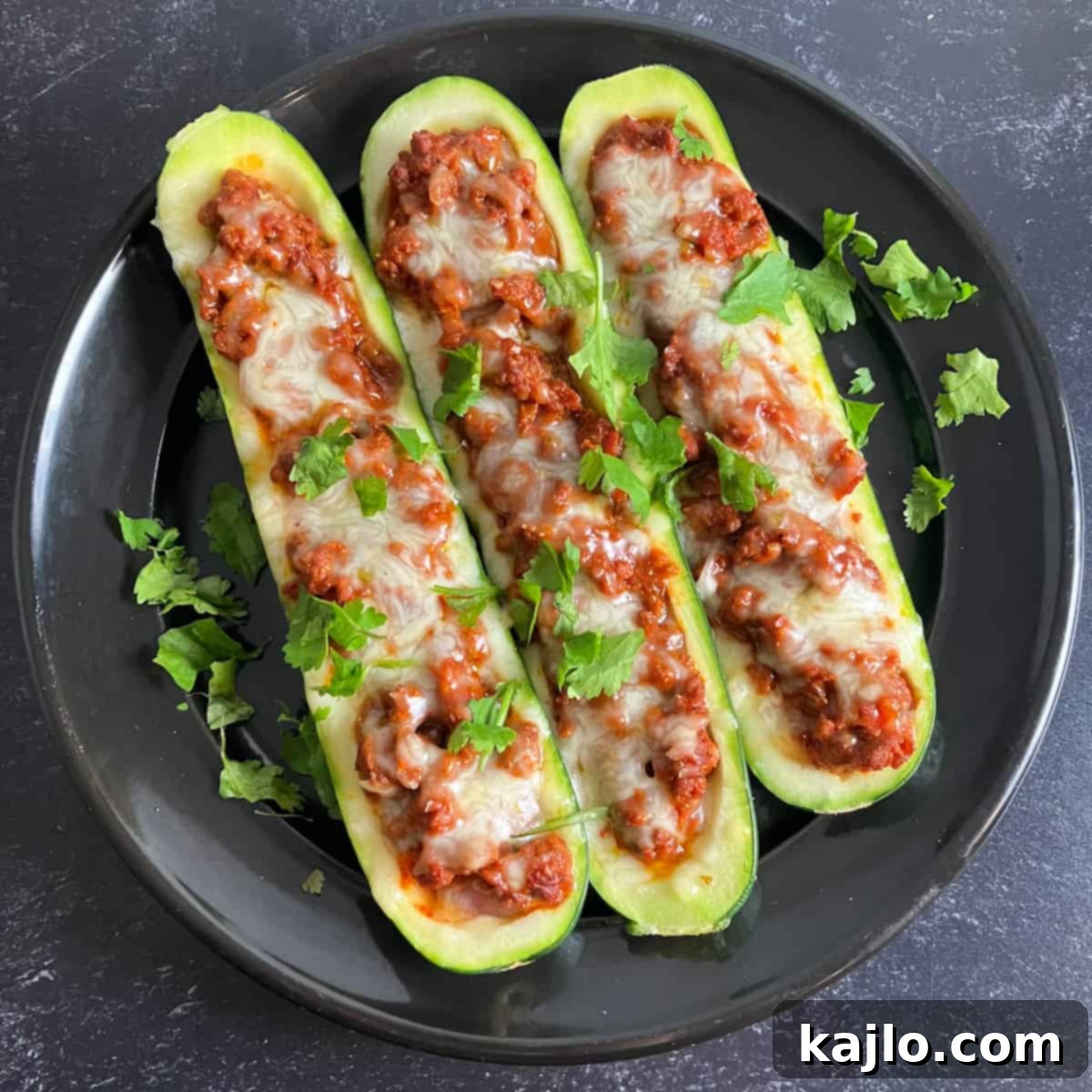 Close-up of a single chorizo stuffed zucchini boat, garnished and ready
