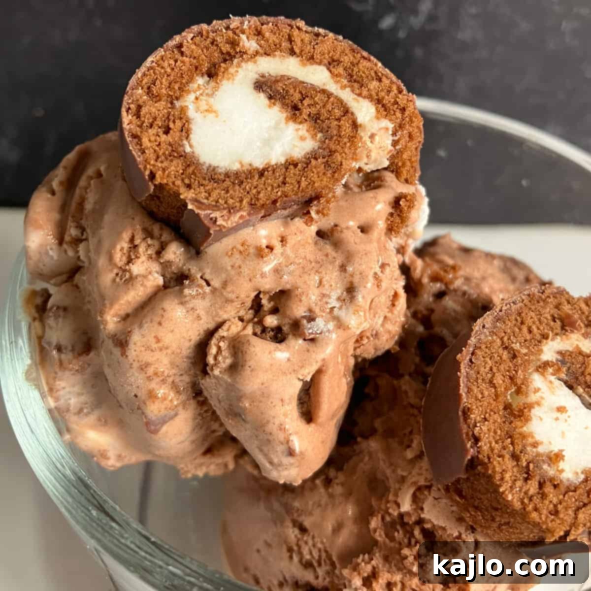 DIY Swiss Roll Ice Cream 6 Finished homemade Swiss Rolls ice cream served with additional slices of Swiss roll on top and a dollop of whipped cream