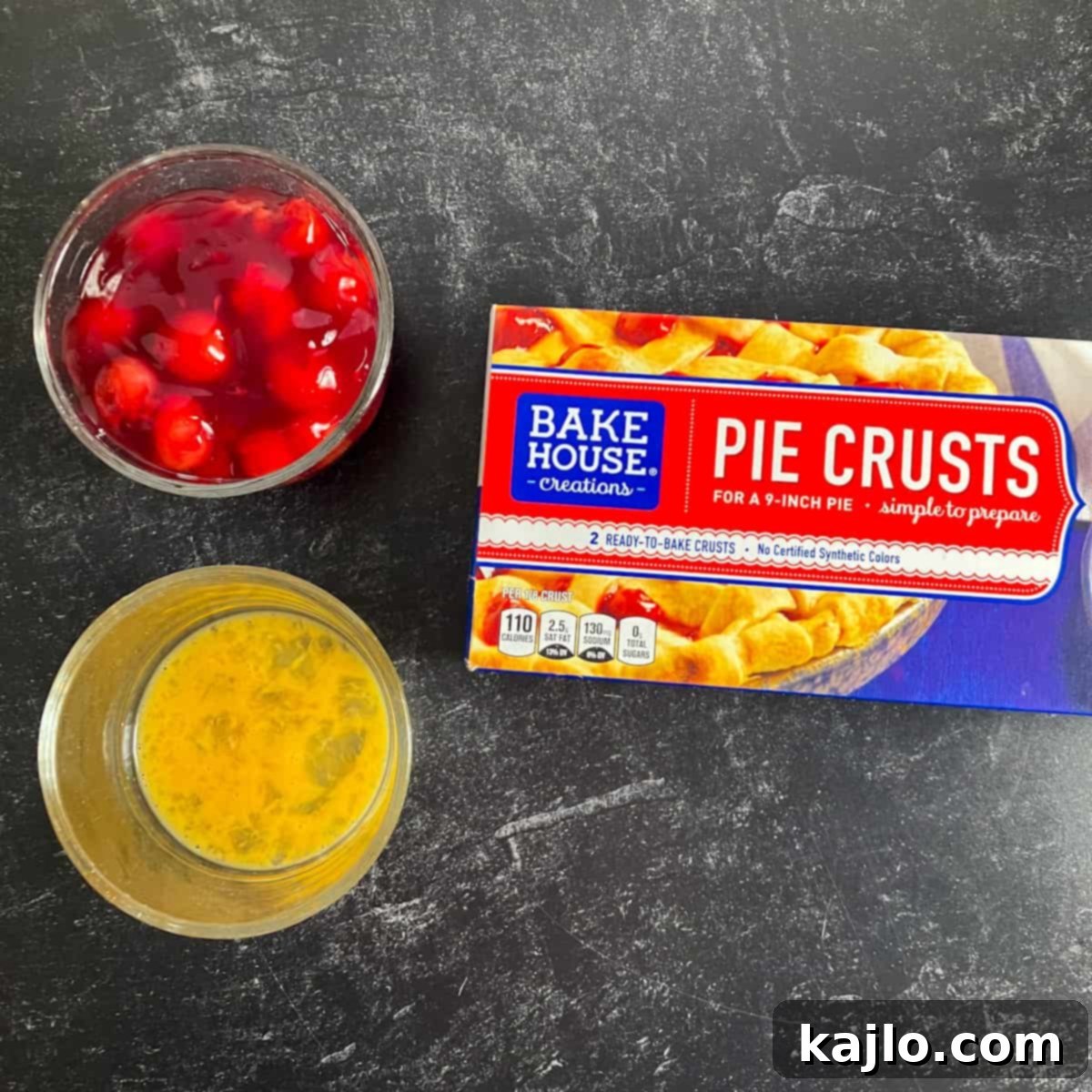 Air Fryer Mini Cherry Pies 3 Collection of ingredients including pie crust, cherry filling, egg, sanding sugar, and cooking spray for an air fryer cherry pie.