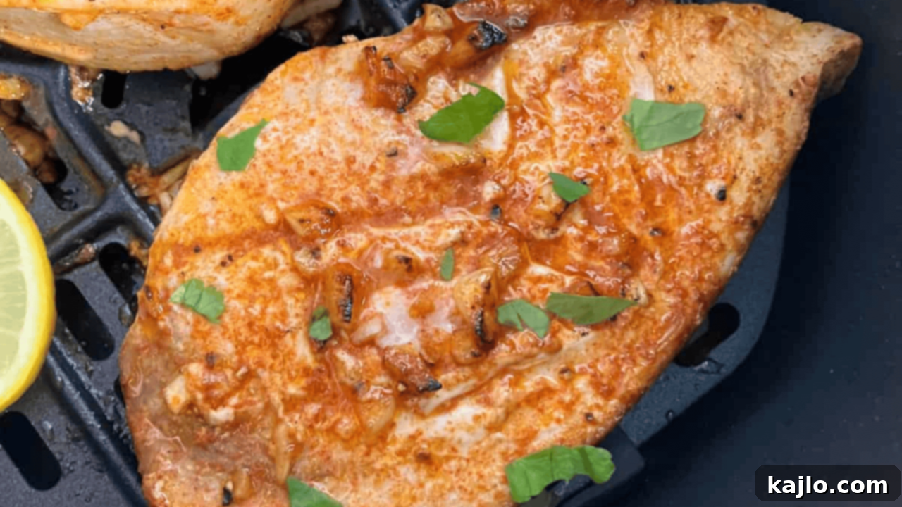 Beautifully grilled-style air fryer swordfish steaks, garnished with fresh herbs and lemon