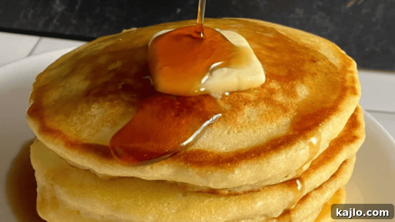 Fluffy Denny's style copycat pancakes drizzled generously with syrup