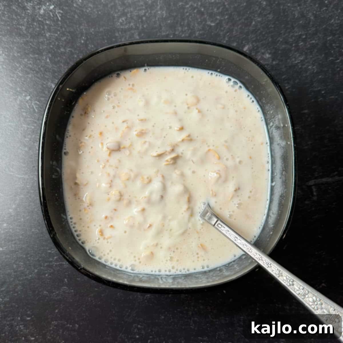 Overnight Oats: Your Favorite Frozen Fruit Creation 4 Mixing oats, yogurt, milk, and lemon zest in a bowl for the overnight oats base.