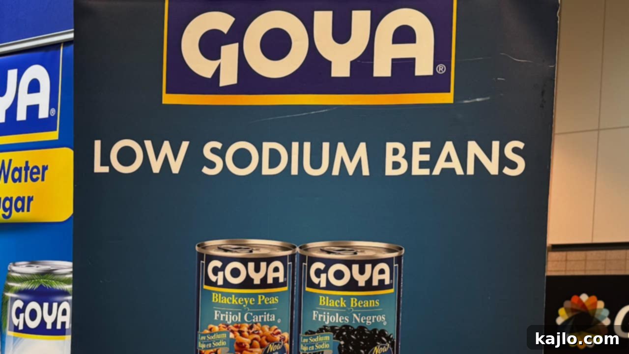Cans of Goya Low Sodium Beans, including black beans, chickpeas, and kidney beans.
