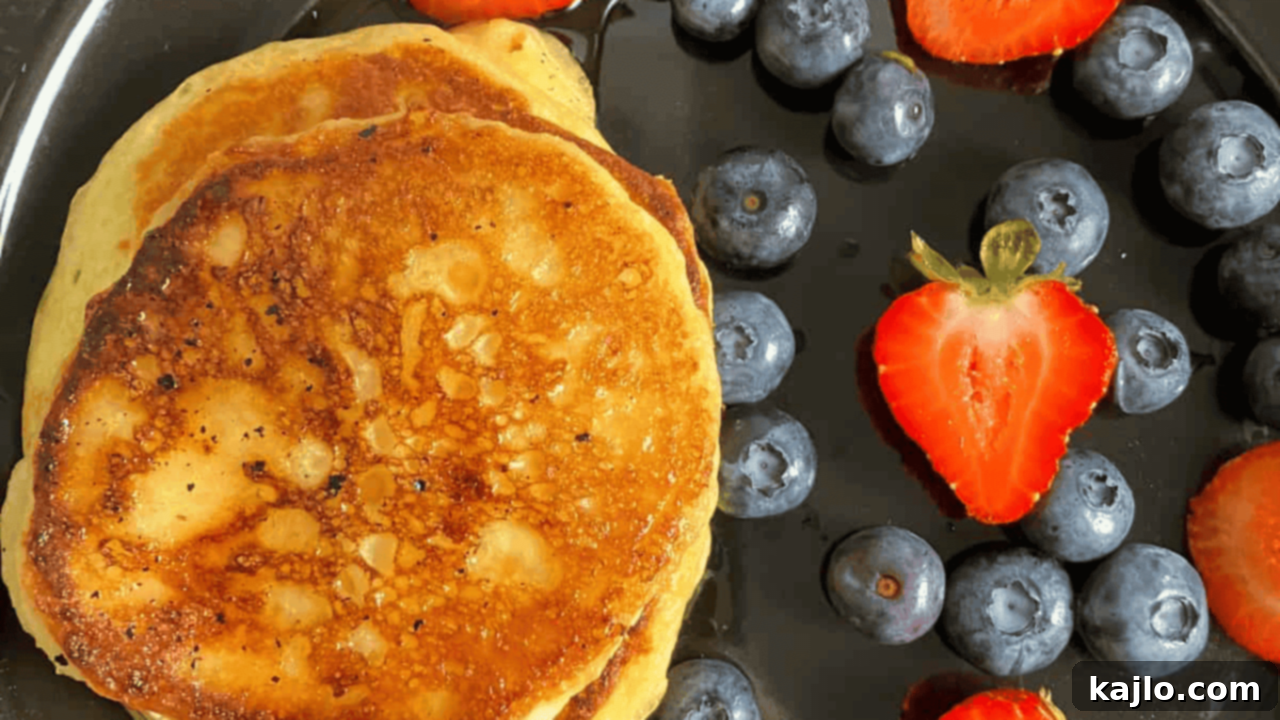 Fluffy quark pancakes stacked high, topped with fresh berries and a dusting of powdered sugar