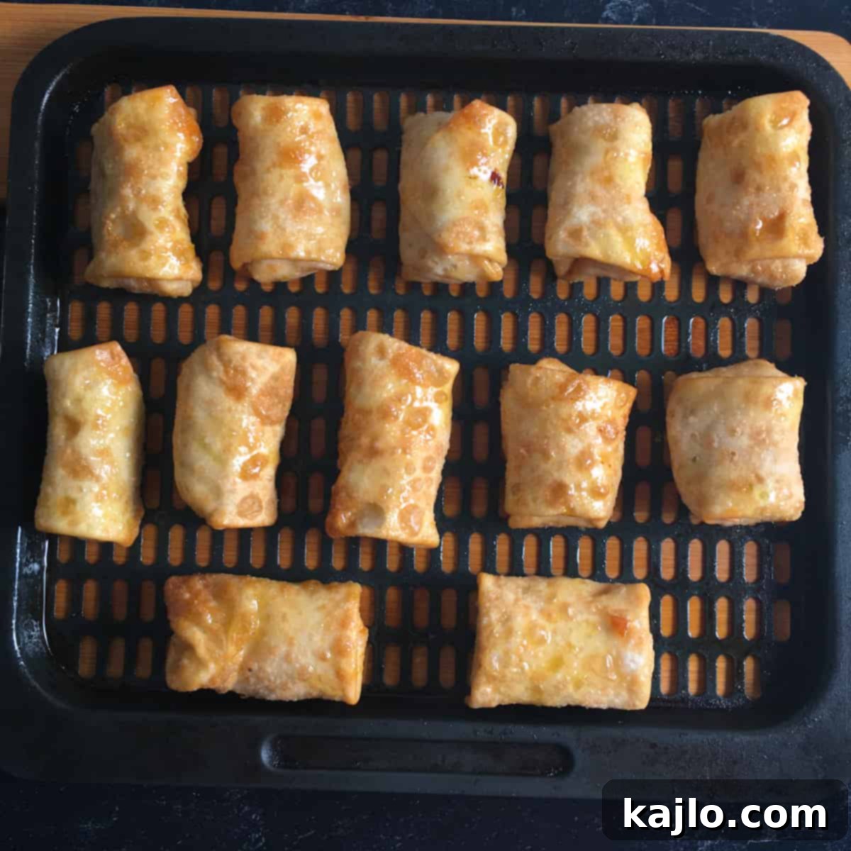 Frozen spring rolls arranged in an air fryer basket