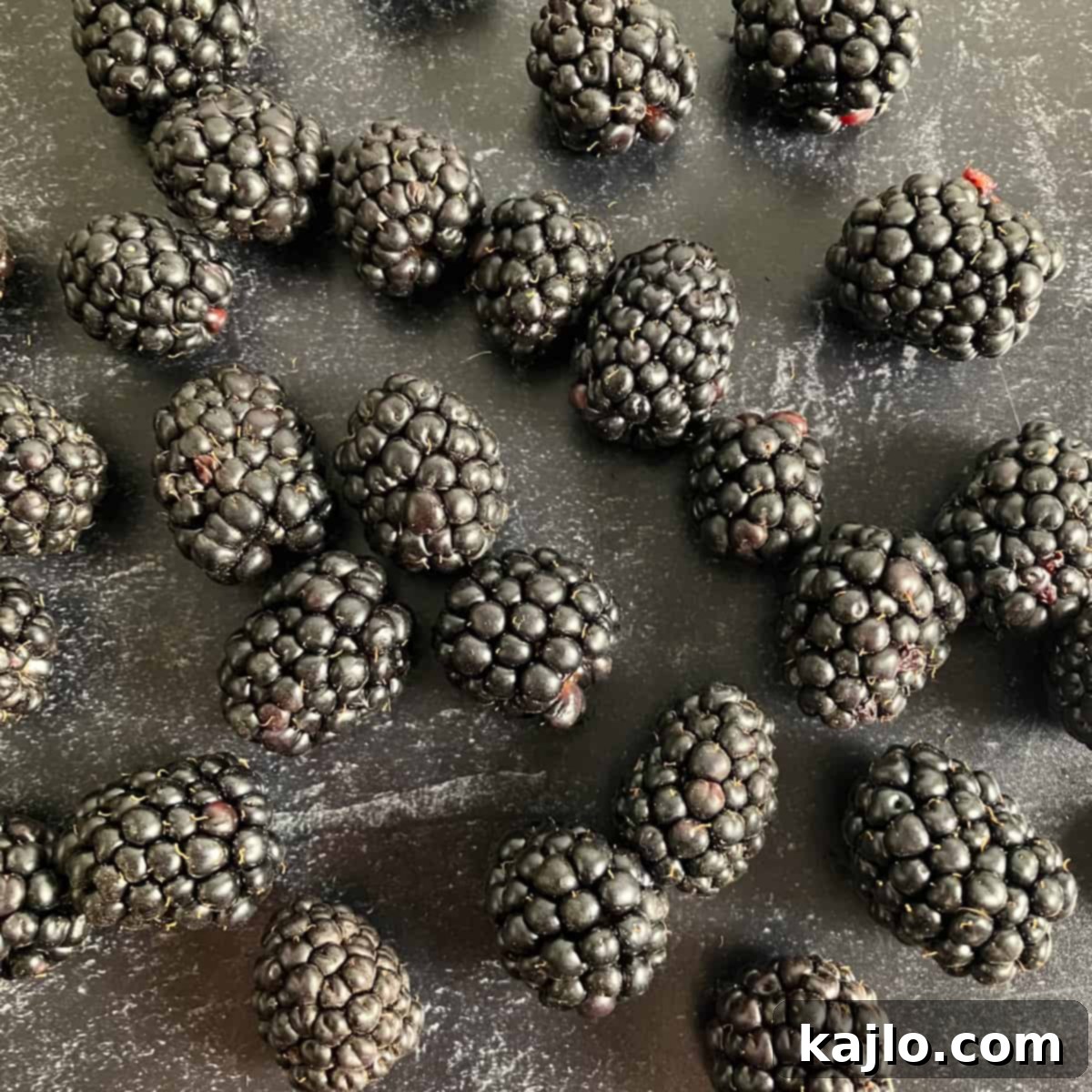 The World of B Fruits Over 40 Varieties Revealed 5 Close-up of fresh, ripe blackberries glistening in the light.