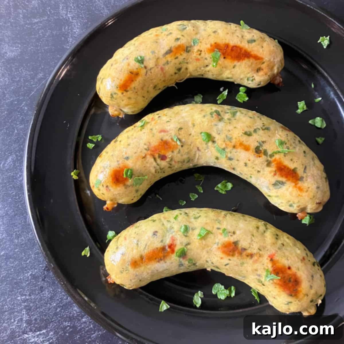 Cooked chicken feta sausage served in a bowl with fresh herbs, ready to eat