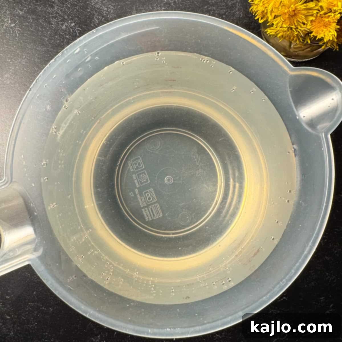 Granulated sugar dissolving in water, forming the base for dandelion vinegar