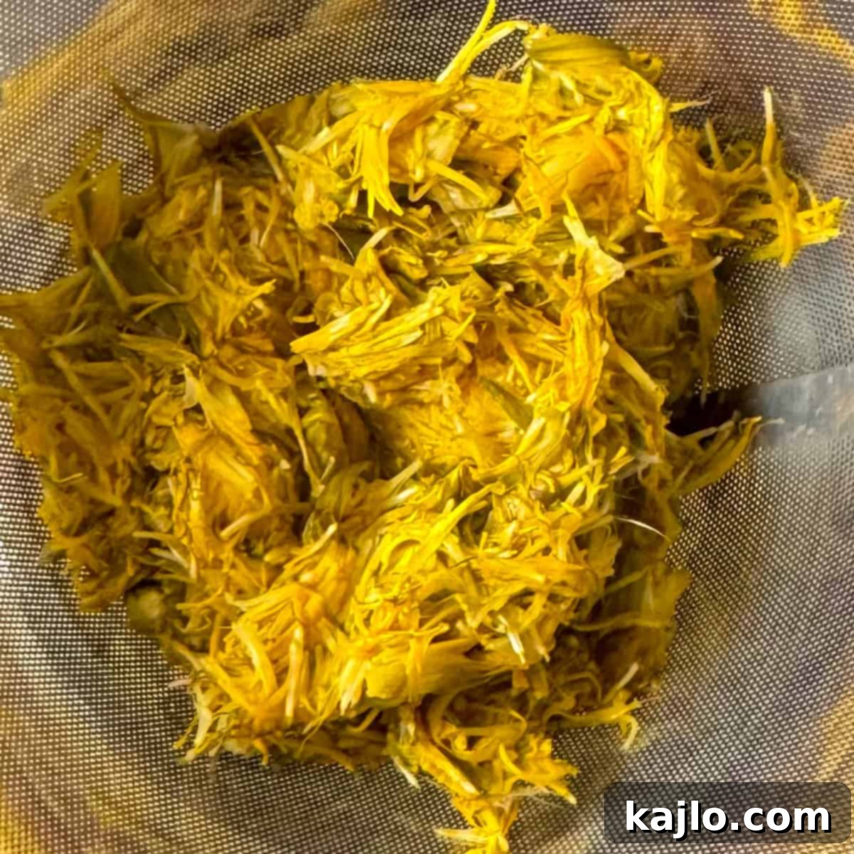 Strained dandelion liquid fermenting in a jar, transforming into vinegar