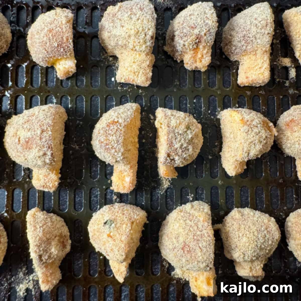 Breaded mushrooms arranged in the air fryer basket