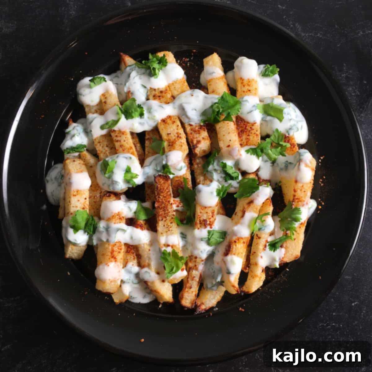 Crispy Air Fryer Jicama Fries with Creamy Keto Vegan Dip 2 Crispy air fried jicama fries seasoned with tajin, next to a bowl of creamy cilantro-lime dipping sauce.