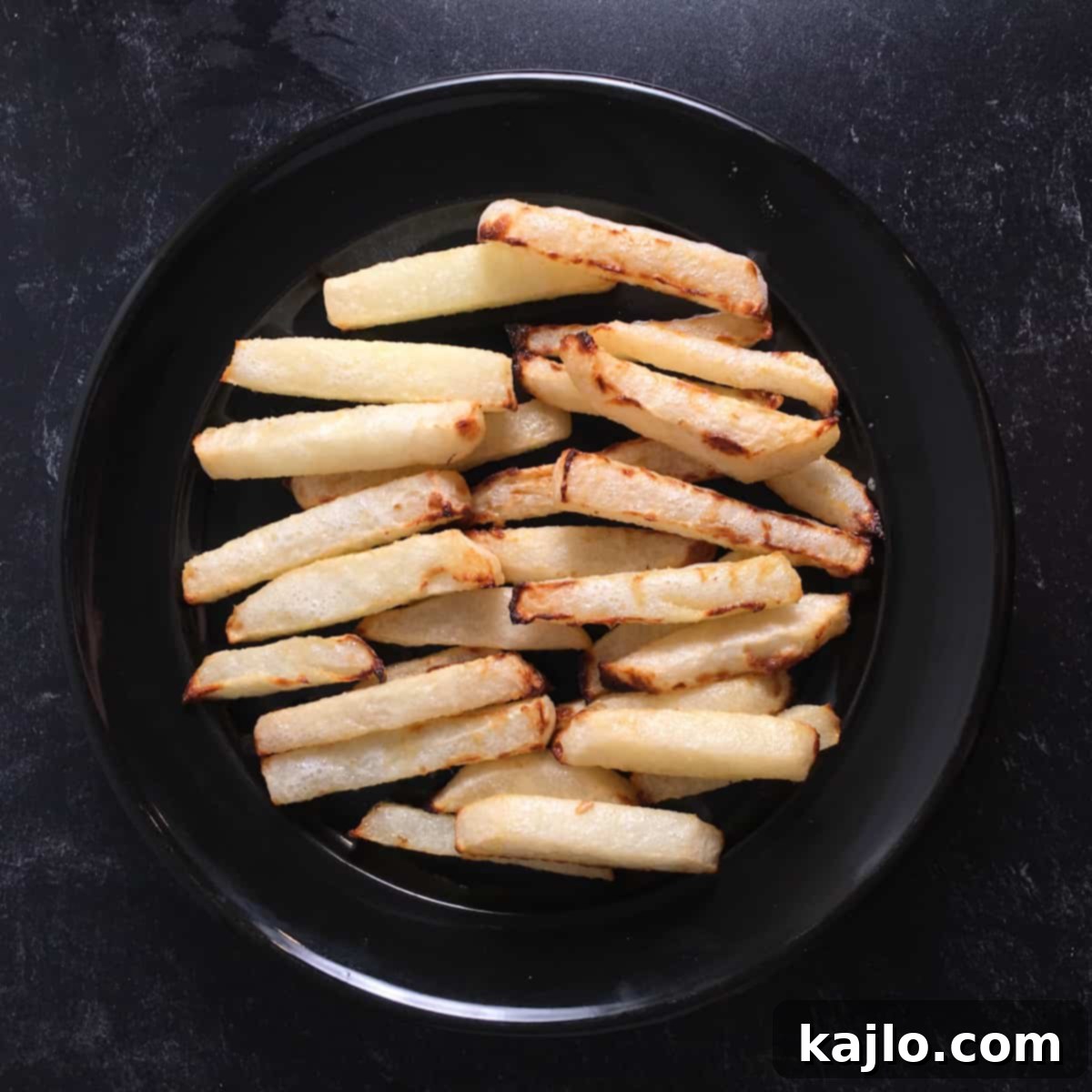 Crispy Air Fryer Jicama Fries with Creamy Keto Vegan Dip 3 A bowl of crispy air fryer jicama fries with tajin seasoning and a creamy cilantro-lime dipping sauce on the side.