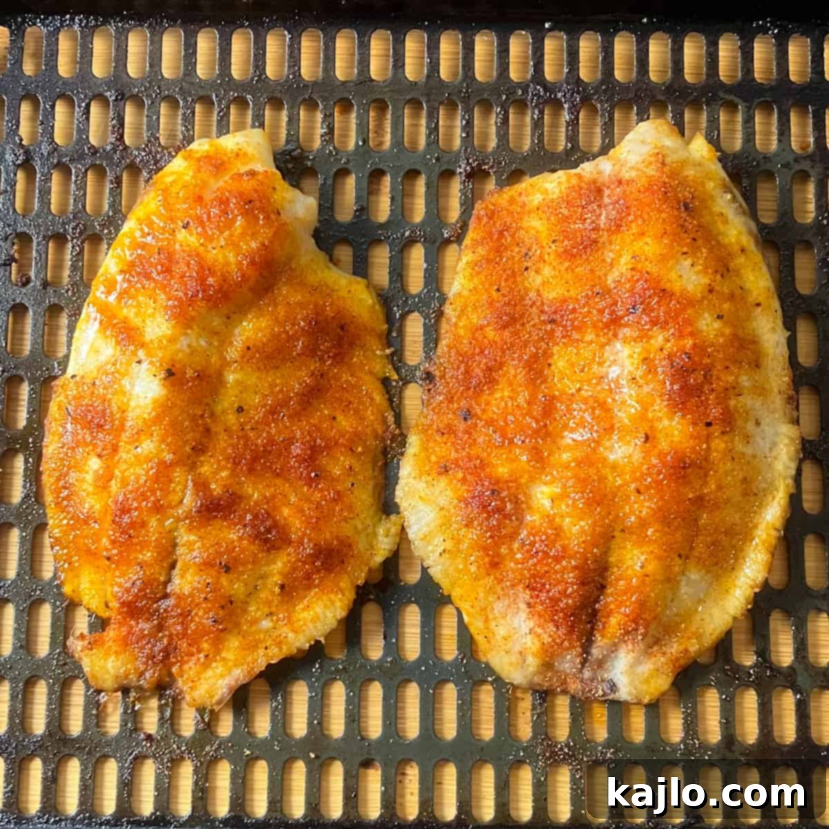 Easy Air Fryer Frozen Tilapia 5 Flipping and seasoning tilapia halfway through air frying.