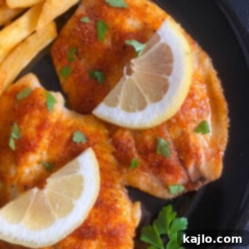 Easy Air Fryer Frozen Tilapia 9 Air fryer cooked tilapia fillet on a plate.