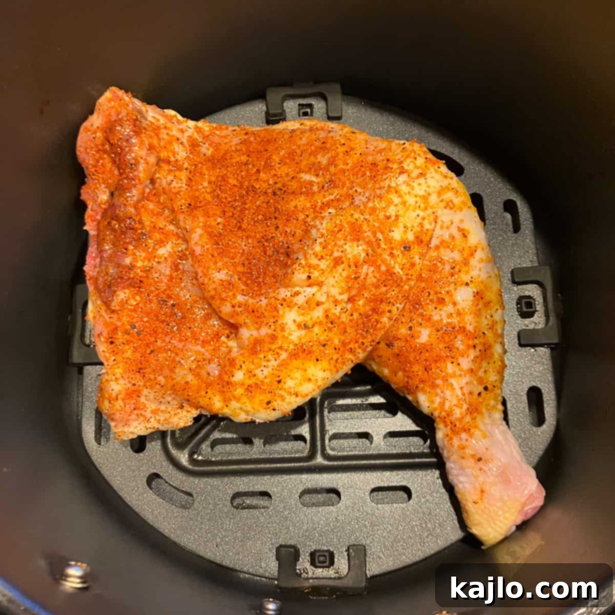 Chicken leg quarter placed in the air fryer basket, skin-side down
