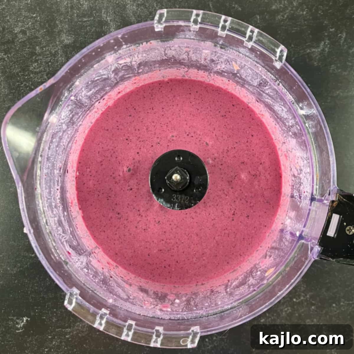 Blended peach and blueberry smoothie in a food processor