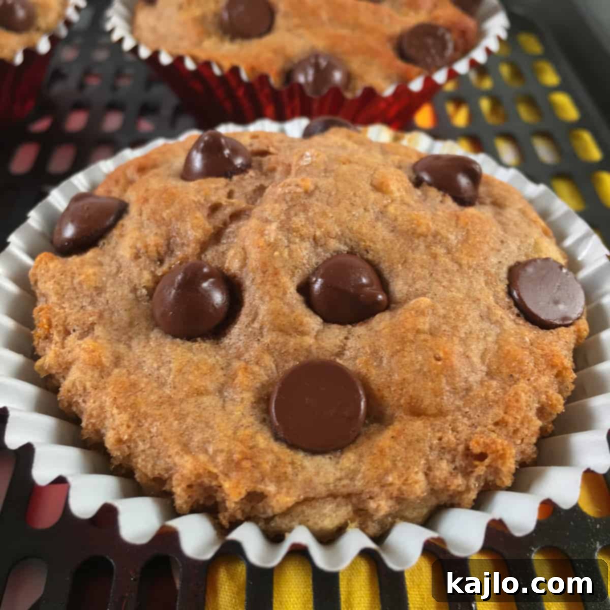 A single air fryer muffin on a plate, showcasing its golden-brown top and soft texture